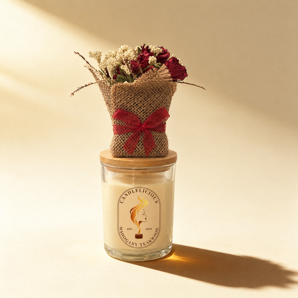 Mahogany Teakwood candle with a burlap-wrapped bouquet of red roses on the lid