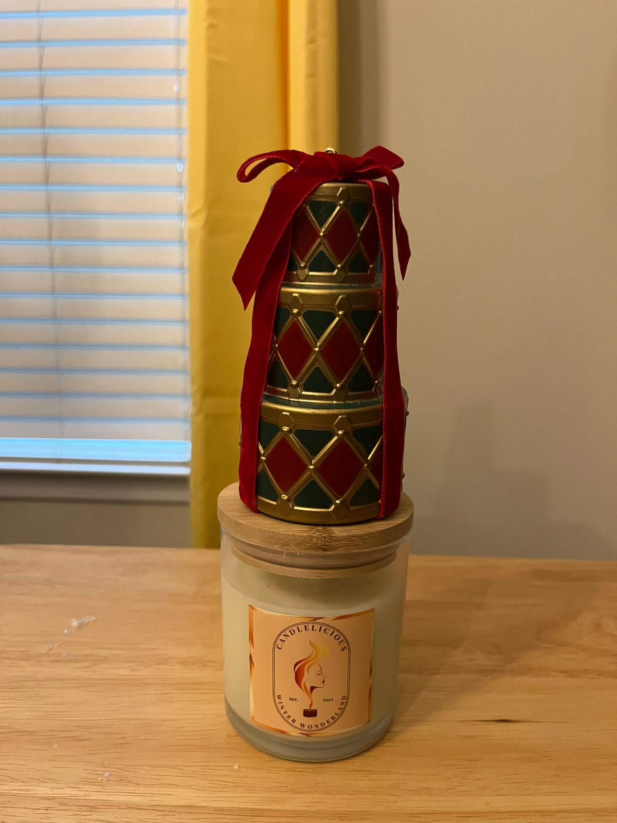 Winter Wonderland candle with a stack of presents tied in red velvet ribbon on the lid