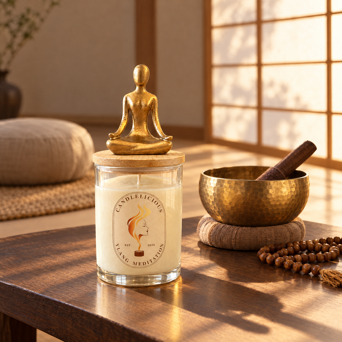 Ylang Meditation candle on a low table beside a brass singing bowl