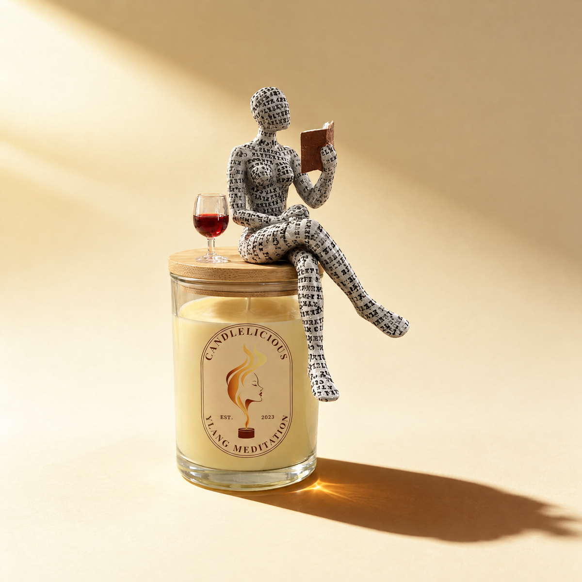 Ylang Meditation candle with a reading figure and a glass of red wine on the lid