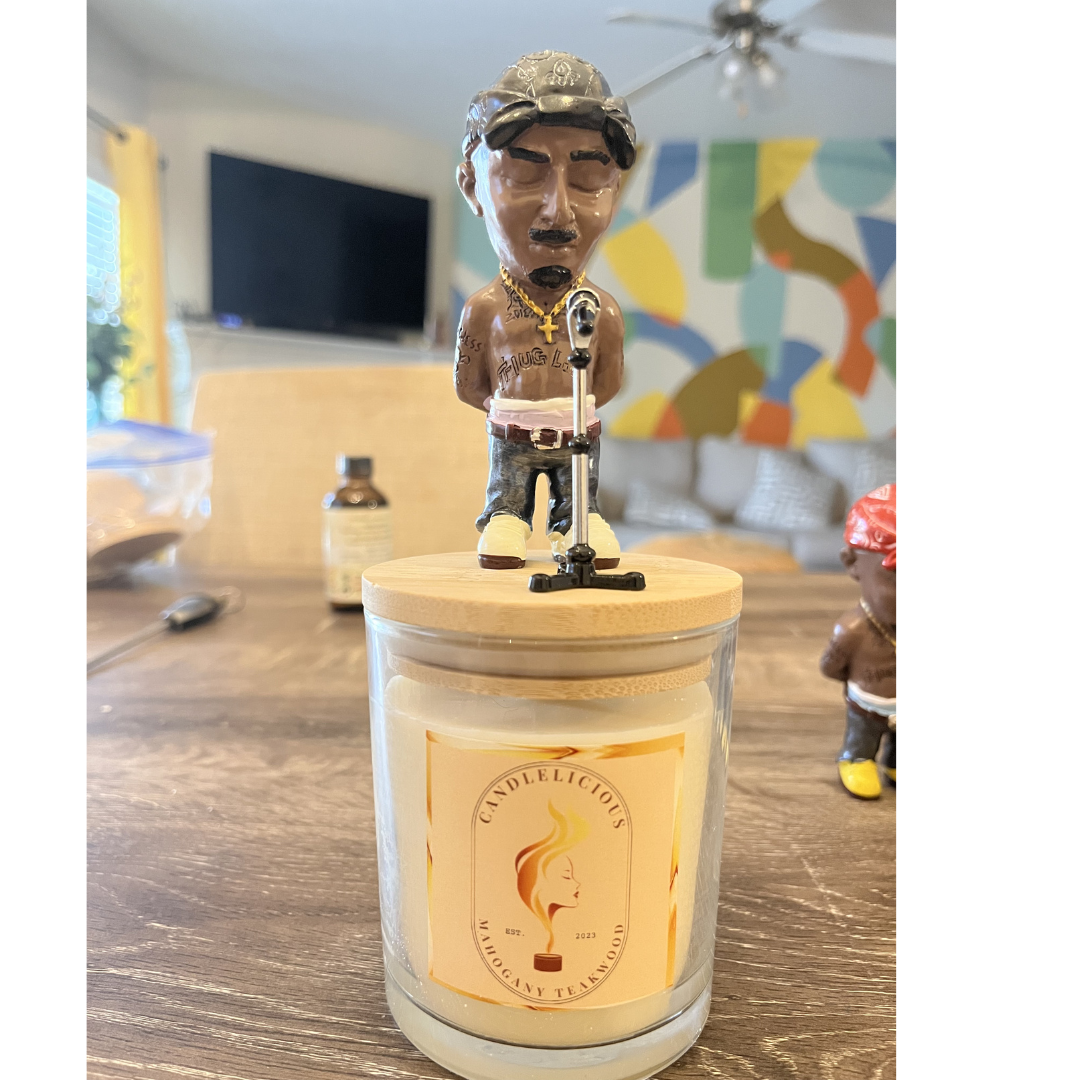 Mahogany Teakwood candle with a Pac figurine in a camo cap at a microphone on the lid