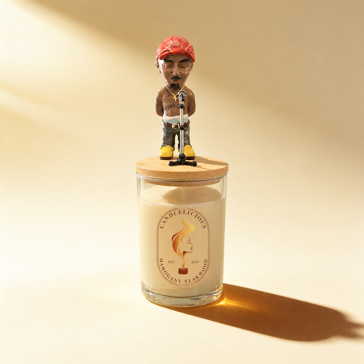 Mahogany Teakwood candle with a Pac figurine in a red bandana at a microphone on the lid