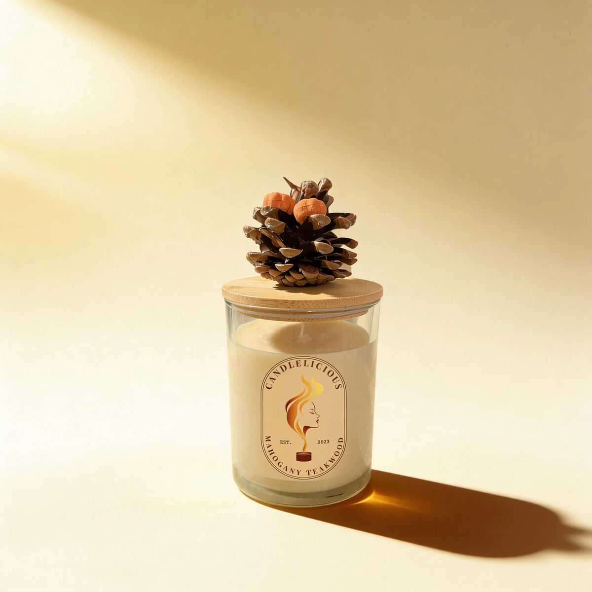 Mahogany Teakwood candle with a pinecone on the lid