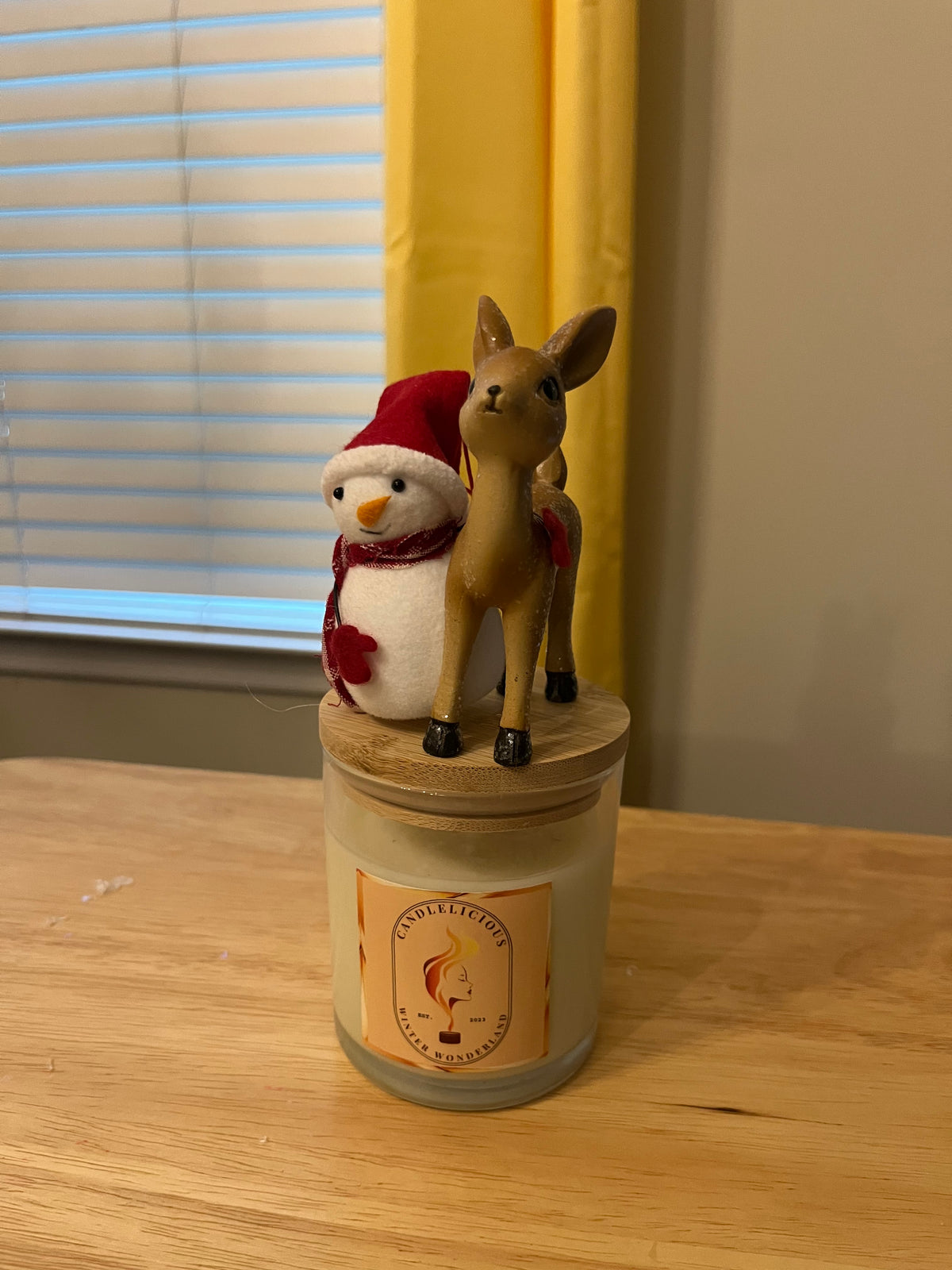 Winter Wonderland candle with a snowman in a Santa hat and a fawn on the lid