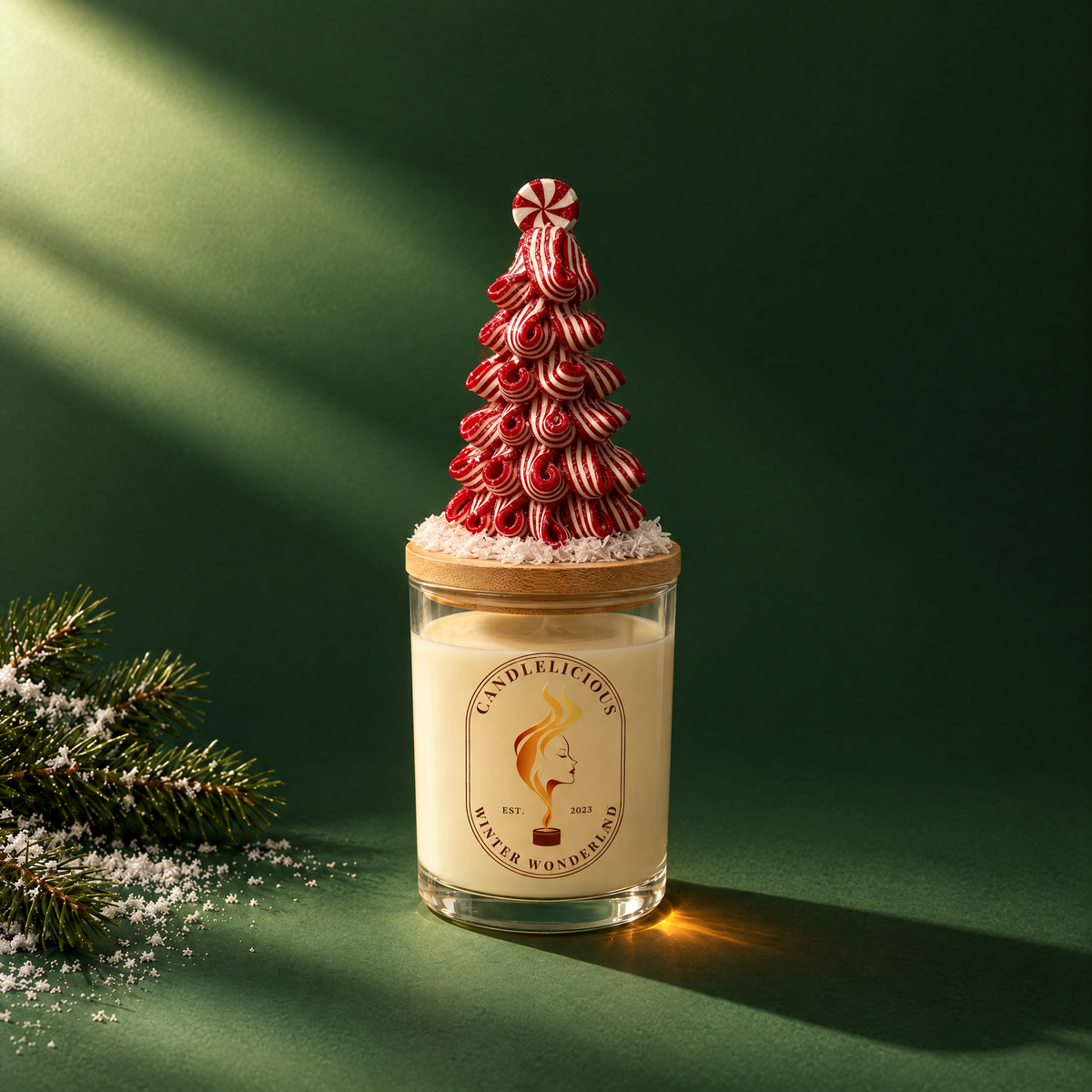 Winter Wonderland candle with a candy-stripe tree on the lid, on an evergreen backdrop