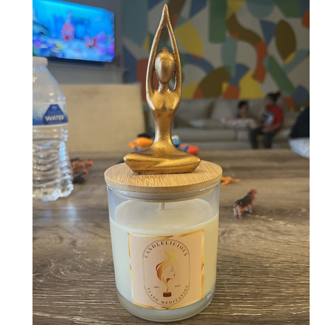 Ylang Meditation candle with a gold yoga figure, arms raised, on the lid